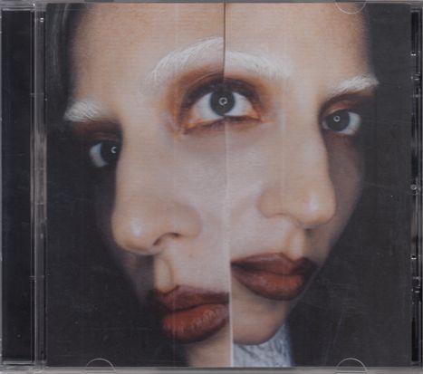 Das Cover zeigt ein Gesicht mit zwei Perspektiven, weißen Augenbrauen und dunkel geschminkten Lippen.
