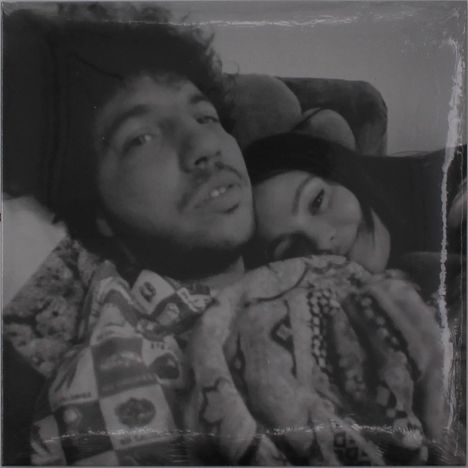 Ein Mann und eine Frau liegen nah beieinander, beide schauen entspannt und ruhig.