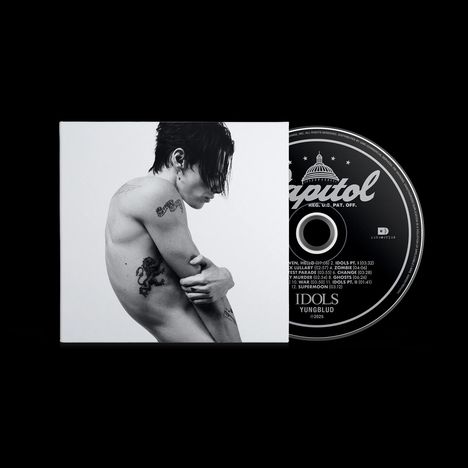 "Capitol", "IDOLS", "YUNGBLUD" auf CD. Schwarz-Weiß-Foto zeigt tätowierte Person von der Seite, Arme um den Körper gelegt.
