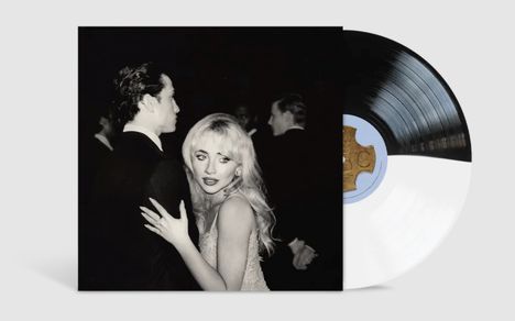 Ein Schwarzweiß-Foto zeigt eine blonde Frau, die einen Mann umarmt. Daneben eine halb sichtbare schwarze Schallplatte.