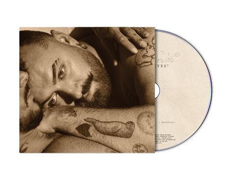 Text: "Smith" und "EYES". Eine Person liegt nachdenklich auf der Seite. Es gibt sichtbare Tattoos.