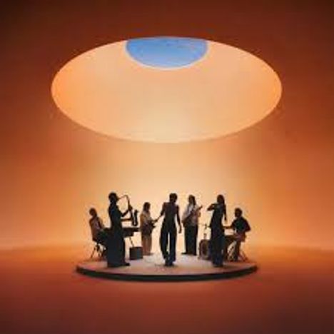 Keine Texte vorhanden. Eine Gruppe von Musikern spielt auf einer Bühne unter einem runden, beleuchteten Dach.