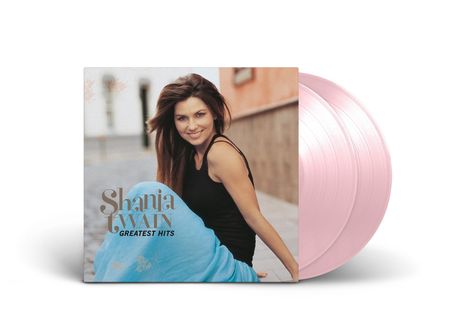 "Shania Twain Greatest Hits" steht auf einem Albumcover. Frau in schwarzem Top, lachend, sitzt draußen. Pinker Vinyl-Schallplattenhintergrund.