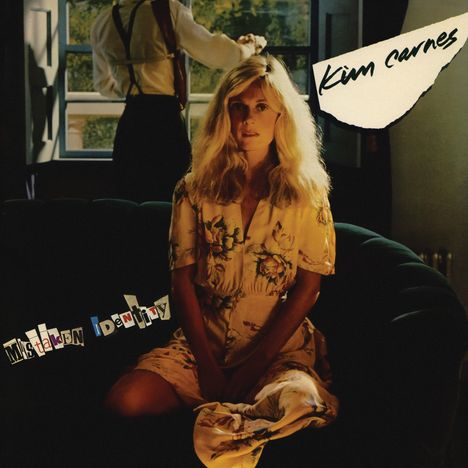 Text: "Kim Carnes", "Mistaken Identity". Eine Frau mit langem blondem Haar sitzt, ein Mann steht am offenen Fenster.