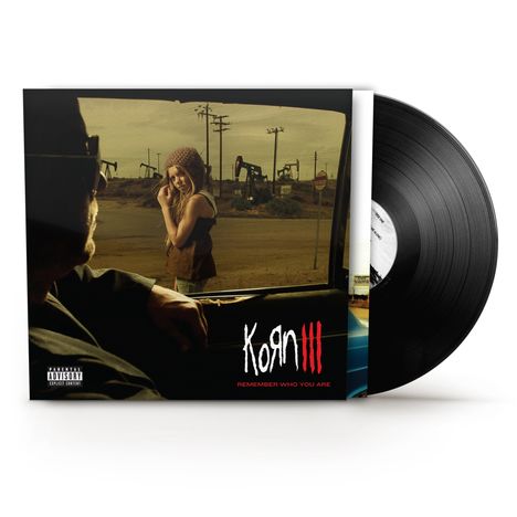 "KoЯn III: Remember Who You Are" steht unten auf einem Albumcover. Eine Frau steht draußen an einem Auto.