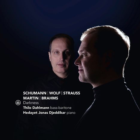 Texte: "Schumann | Wolf | Strauss | Martin | Brahms", "Darkness", "Thilo Dahlmann bass-baritone", "Hedayet Jonas Djeddikar piano". Zwei Männer in dunkler Umgebung.