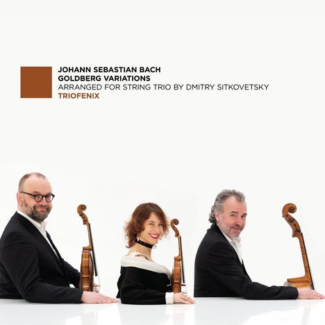 JOHANN SEBASTIAN BACH GOLDBERG VARIATIONS. Drei Musiker lächeln mit Instrumenten zur Seite.