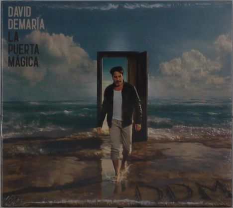 Text: "DAVID DEMARÍA LA PUERTA MÁGICA". Ein Mann schreitet aus einer Tür, die am Strand steht, in die Wellen.