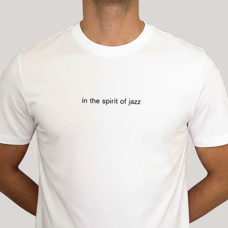 Text "in the spirit of jazz" auf einem weißen T-Shirt. Person trägt das Shirt, ohne sichtbares Gesicht.
