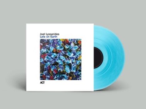 Text: "Joel Lyssarides - Late on Earth." Ein blaues Vinyl vor abstraktem, buntem Kunstwerk auf weißem Hintergrund.