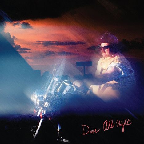 Text: "Drive All Night". Sonnenuntergang, Motorradfahrer mit Sonnenbrille und Mütze, im Scheinwerferlicht.