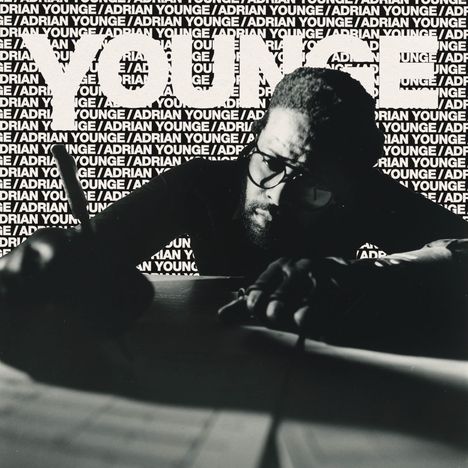 Text: "YOUNGE / ADRIAN YOUNGE" wiederholt im Hintergrund. Mann mit Brille schreibt konzentriert.