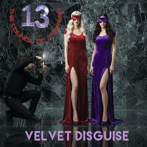„13“, „THE COUNCIL OF THE NEEDLESS“, „VELVET DISGUISE“. Zwei Frauen in roten und violetten Kleidern, Fotograf kniet.