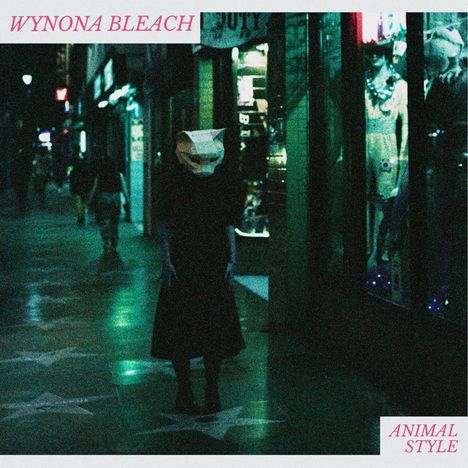 "WYNONA BLEACH" und "ANIMAL STYLE" in pinker Schrift. Eine Person mit Katzenmaske steht auf einem nächtlich beleuchteten Gehweg.