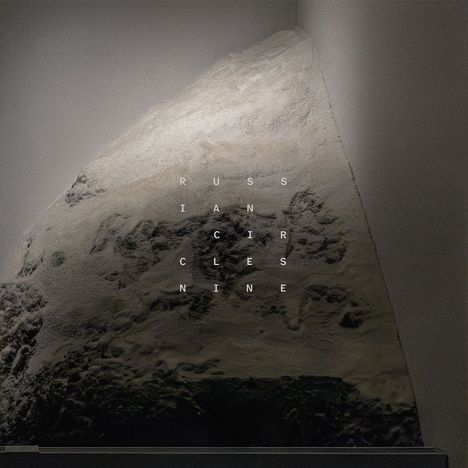 Text: "RUSSIAN CIRCLES NINE". Eine abstrakte Darstellung einer rautenförmigen Struktur in Grautönen.
