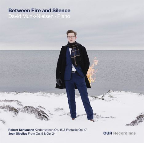 "Between Fire and Silence", David Munk-Nielsen · Piano. Mann in Winterlandschaft, Flammen im Hintergrund.
