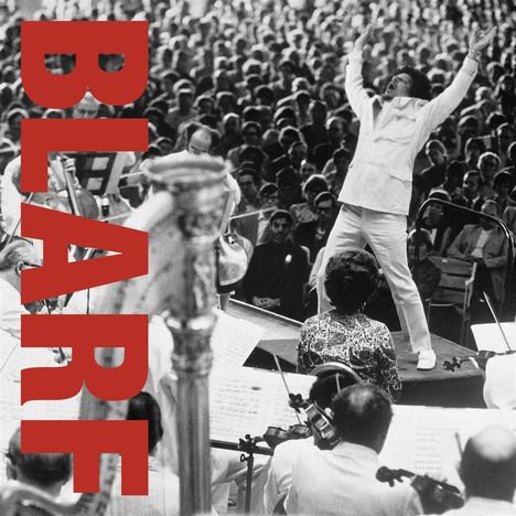 Text "BLARE" in großer roter Schrift über einem dirigierenden Mann vor einem Orchester und einem großen Publikum.