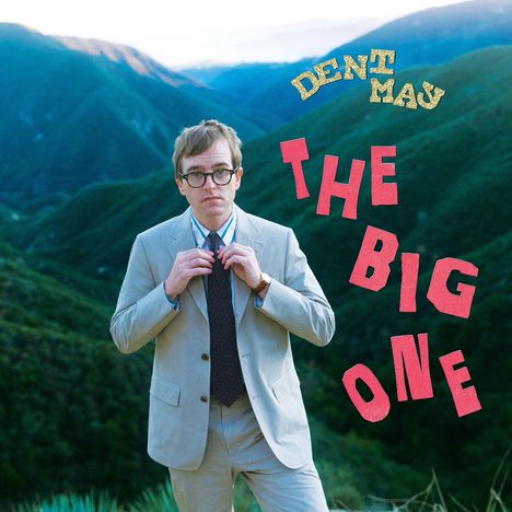 Oben Text: "Dent May", daneben groß "The Big One". Ein Mann im Anzug steht vor grünen Bergen.