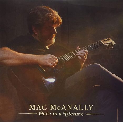 "MAC McANALLY - Once in a Lifetime." Ein Mann spielt sanft Gitarre in gedämpftem Licht, sein Gesicht teils beschattet.