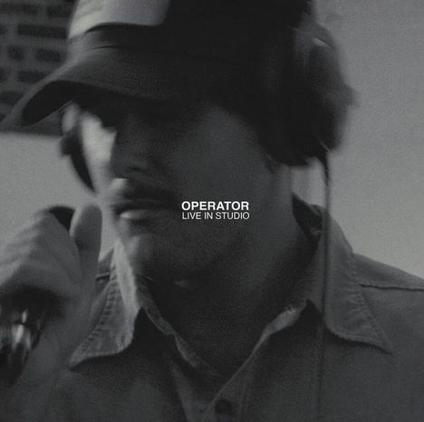 TEXT: "OPERATOR LIVE IN STUDIO". Ein unscharfer Mensch mit Kopfhörer und Mikrofon.