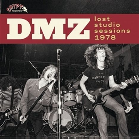 "DMZ lost studio sessions 1978." Rockband mit drei Musikern auf einer Bühne in dynamischer Pose.