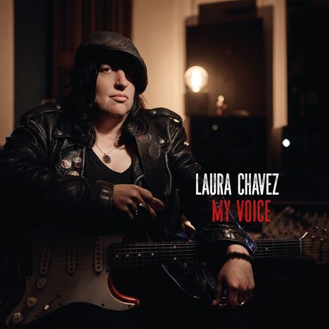 Text: "LAURA CHAVEZ MY VOICE". Eine Person in Lederjacke, sitzt mit einer E-Gitarre in einem abgedunkelten Raum.