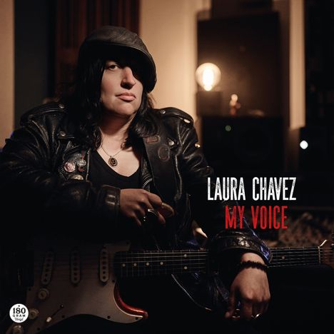 Text: "Laura Chavez, My Voice." Eine Person mit Lederjacke und Gitarre, spärlich beleuchteter Raum im Hintergrund.