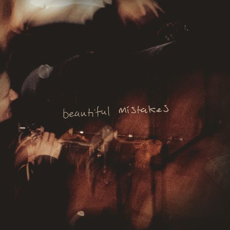 Text: "beautiful mistakes". Verschwommene Szene mit Musikern und warmen Licht.