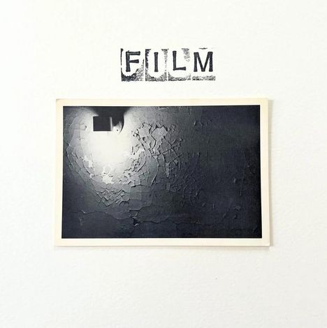 Oben steht "FILM". Darunter ein schwarz-weiß Foto einer Wand mit schälender Farbe und einer Lampe oben links.