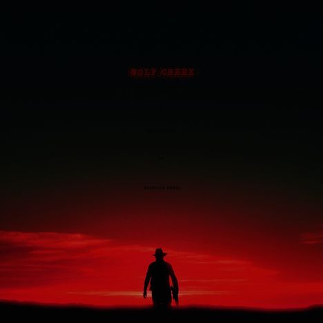 "Wolf Creek" in roter Schrift. Silhouette einer Person mit Hut und Gewehr vor einem roten Abendhimmel.