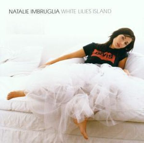 "NATALIE IMBRUGLIA WHITE LILIES ISLAND." Frau in weißem Kleid liegend, entspannt auf einem weißen Sofa.