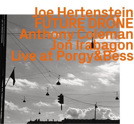 Joe Hertenstein FUTURE DRONE Anthony Coleman Jon Irabagon Live at Porgy&Bess. Schwarzes Gebäude und Wolken im Himmel.