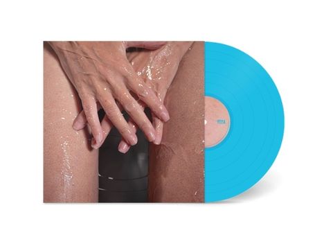 Text „SEA“ auf einem blauen Vinyl-Plattencover. Zwei nasse Hände ruhen auf Oberschenkeln.