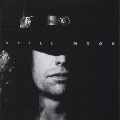 Der Text "STILL MOON" ist über dem Gesicht einer Person mit schwarzem Hut und Schatten platziert.