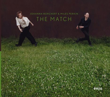 Johanna Borchert & Miles Perkin, The Match. Zwei Personen stehen auf einer grünen Wiese vor einer dunklen Wand.
