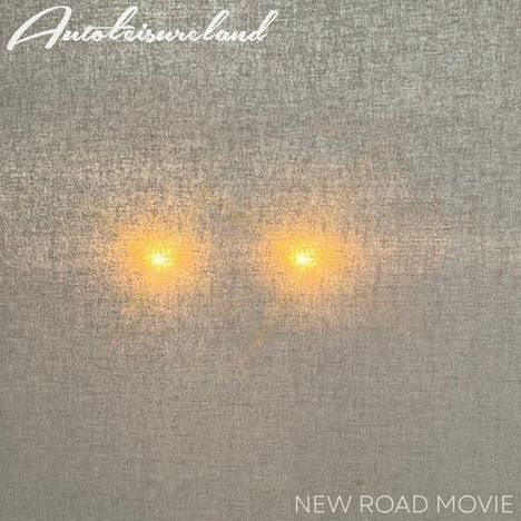 Text: "Autoclassureland" oben links, "NEW ROAD MOVIE" unten rechts. Zwei gelbe Lichter schimmern durch grauen Stoff.