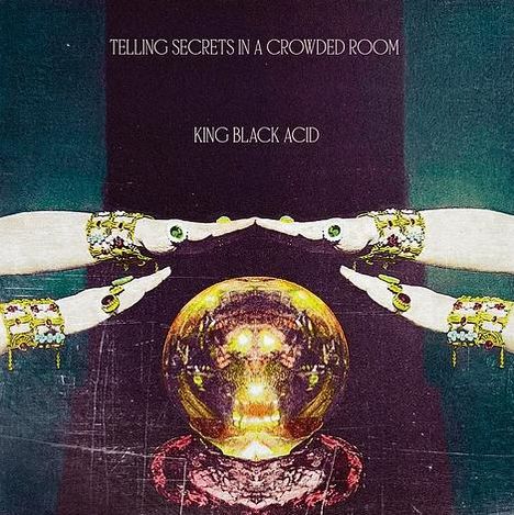 Text: "Telling Secrets in a Crowded Room", "King Black Acid". Hände mit Schmuck umgeben eine Kristallkugel.