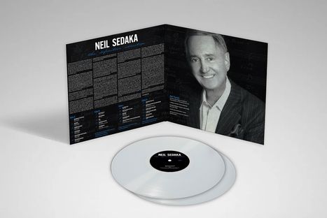 "NEIL SEDAKA - the definitive collection" steht oben. Darunter öffnet sich ein Plattencover mit Porträt. Weiße Vinyl-Schallplatte.