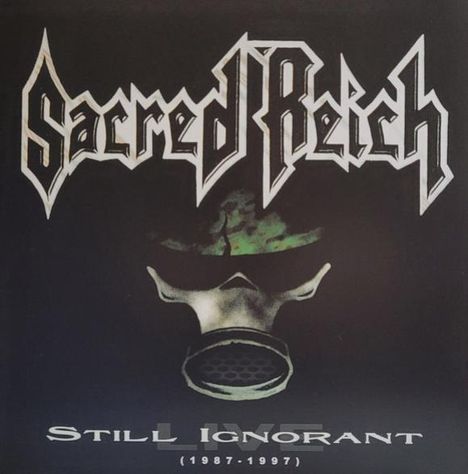 Text: "Sacred Reich" oben, "Still Ignorant (1987-1997)" unten. Maskenbild zeigt Gasmaske vor dunklem Hintergrund.