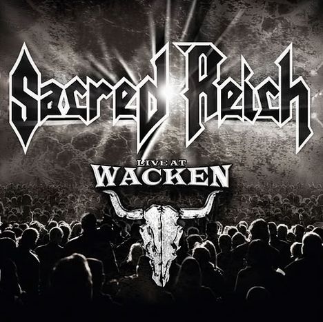 "Sacred Reich", "Live at Wacken" in großen Buchstaben, darunter ein Stierkopf-Logo, Publikum im Vordergrund.
