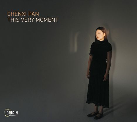 "CHENXI PAN - THIS VERY MOMENT." Eine Frau in schwarzer Kleidung steht im Spotlight vor einem dunklen Hintergrund. Logo unten links.