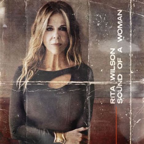 RITA WILSON SOUND OF A WOMAN steht links. Frau mit langen Haaren in schwarzem Oberteil schaut ernst. Vintage-Stil.