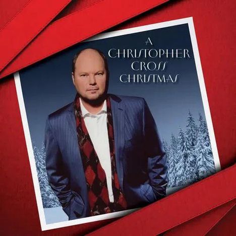 "A Christopher Cross Christmas" steht oben. Eine Person in einem Anzug vor einem verschneiten Wald, umrahmt von roten Schleifen.