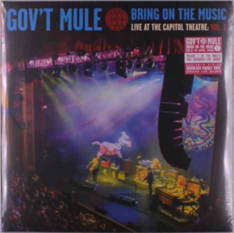„GOV'T MULE“, „BRING ON THE MUSIC“, „LIVE AT THE CAPITOL THEATRE: VOL. 1“. Bühne mit buntem Licht und Musikern.