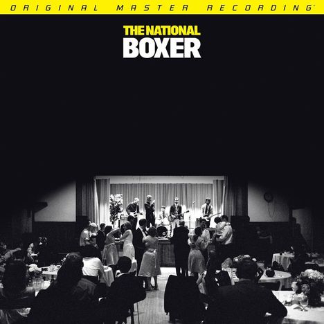 "ORIGINAL MASTER RECORDING" oben, "THE NATIONAL BOXER" darunter. Schwarz-weiß Foto einer Band, die vor Tanzenden spielt.