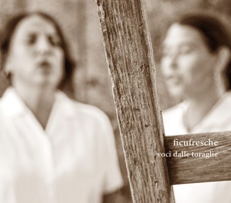 Text: "ficufresche voci dalle toraglie". Zwei unscharfe Personen hinter rustikalem Holzzaun in Sepia-Ton.
