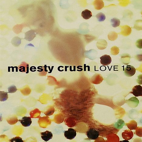Text: "majesty crush LOVE 15". Verschwommene, bunte Kugeln über einem unscharfen Hintergrund.