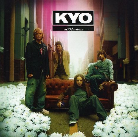 KYO, 300 lésions. Vier Männer in einer Gasse, umgeben von weißen Blumen, einer sitzt auf einem Sofa.