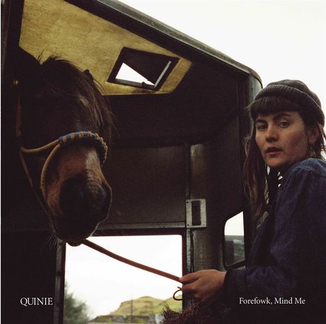 Texte: „QUNIE“ und „Forefowk, Mind Me“. Eine Person hält ein Pferd an der Leine in einem Pferdeanhänger.