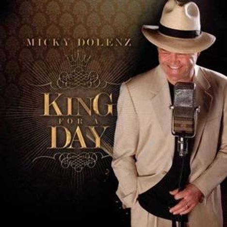 Text: "MICKY DOLENZ, KING FOR A DAY." Ein Mann im Anzug mit Hut steht neben einem Retro-Mikrofon.